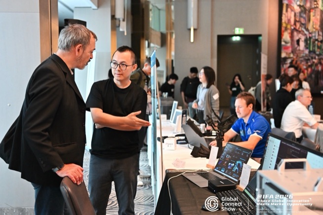 Attendees in conversation at a demo table, GCS IFA 2026